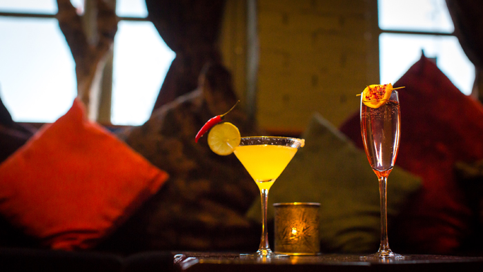 Cocktail glass with yellow drink and slice of lemon